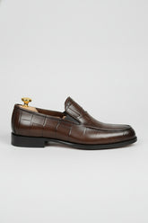 Brown crocodile-embossed slip-on shoes with elegant leather finish for formal wear.
